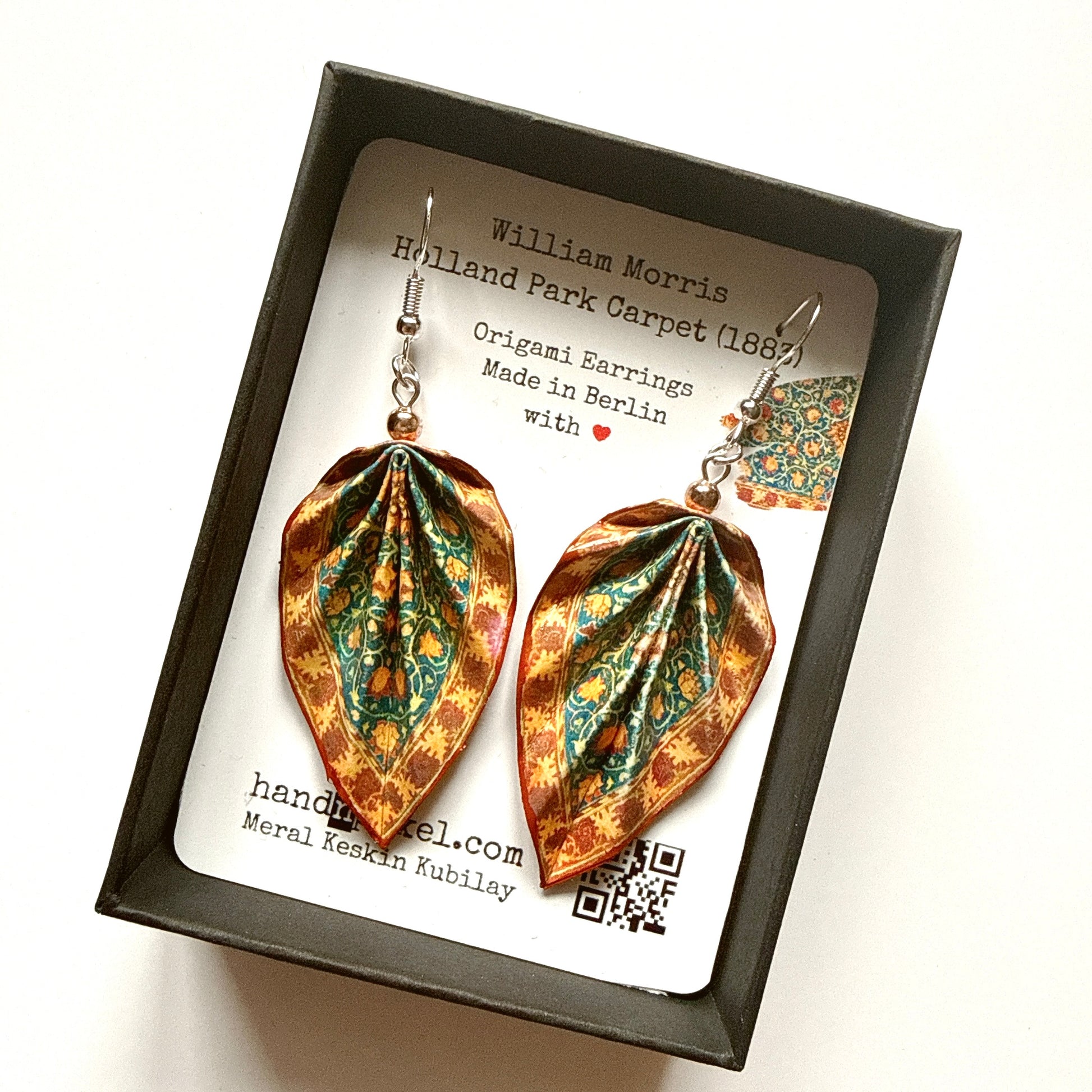 Decorative earrings in a box with a card detailing the design inspiration.