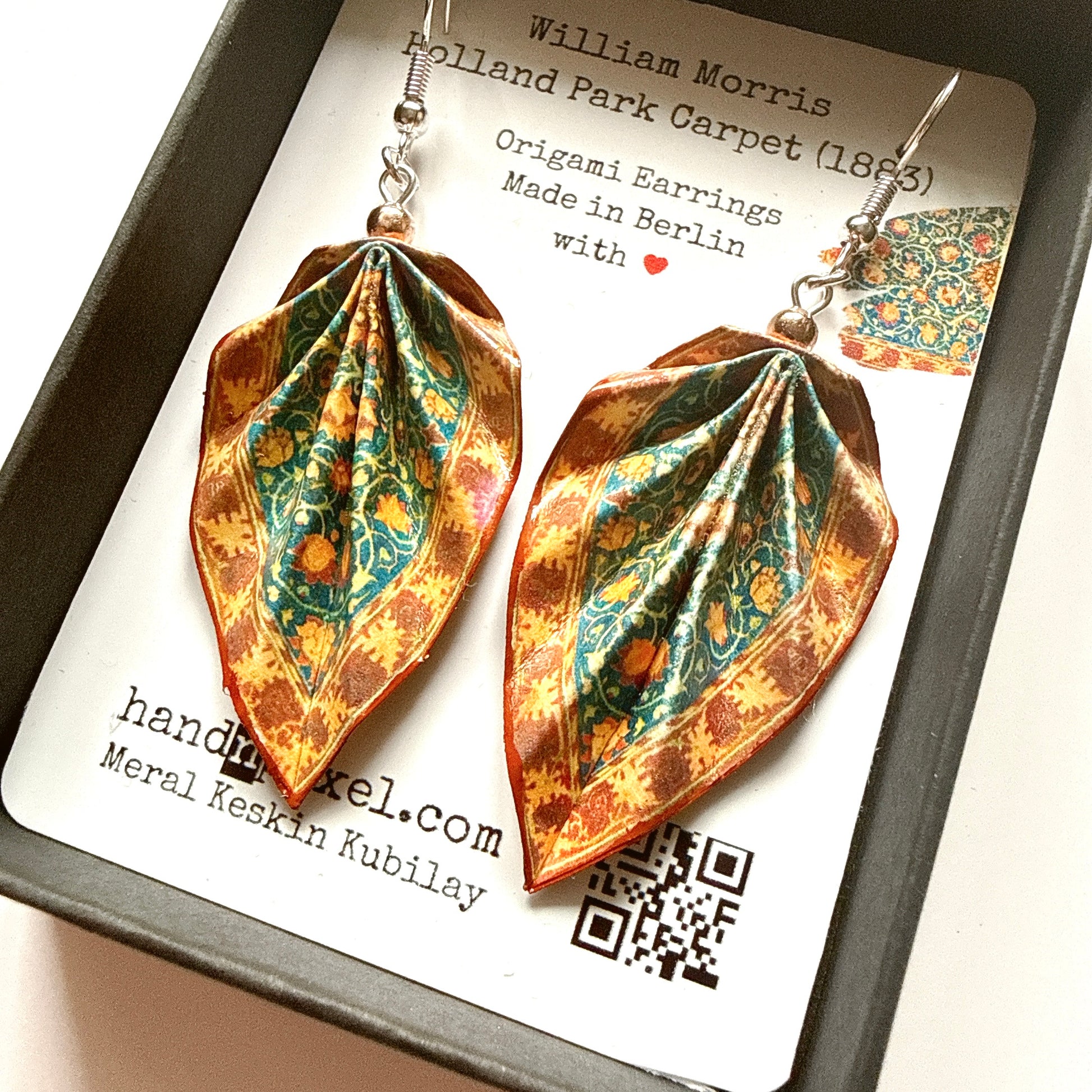 Pair of origami earrings on a card with branding details