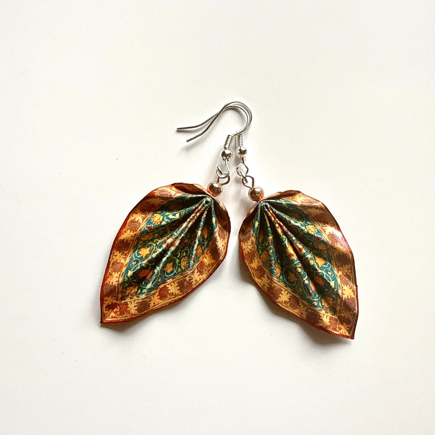 Leaf-shaped earrings with floral patterns on a white background