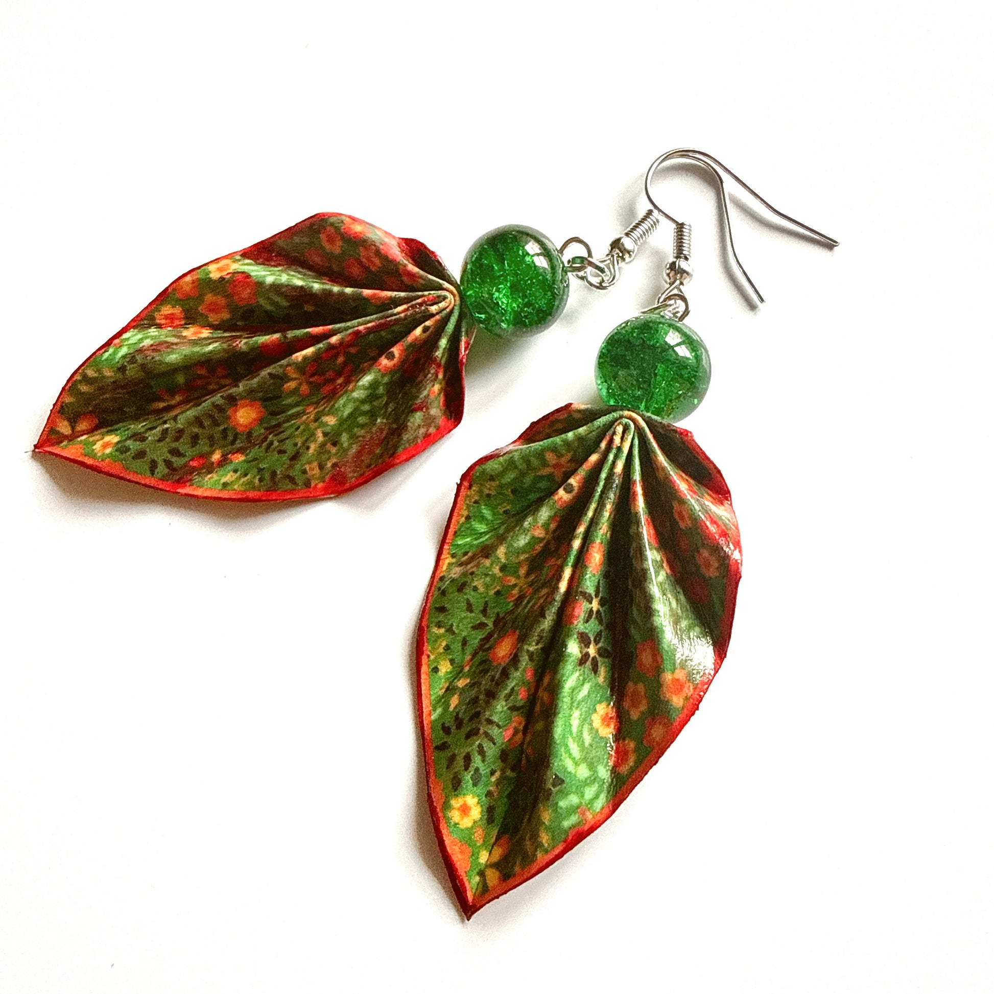 Leaf-shaped earrings with green and red pattern on a white background