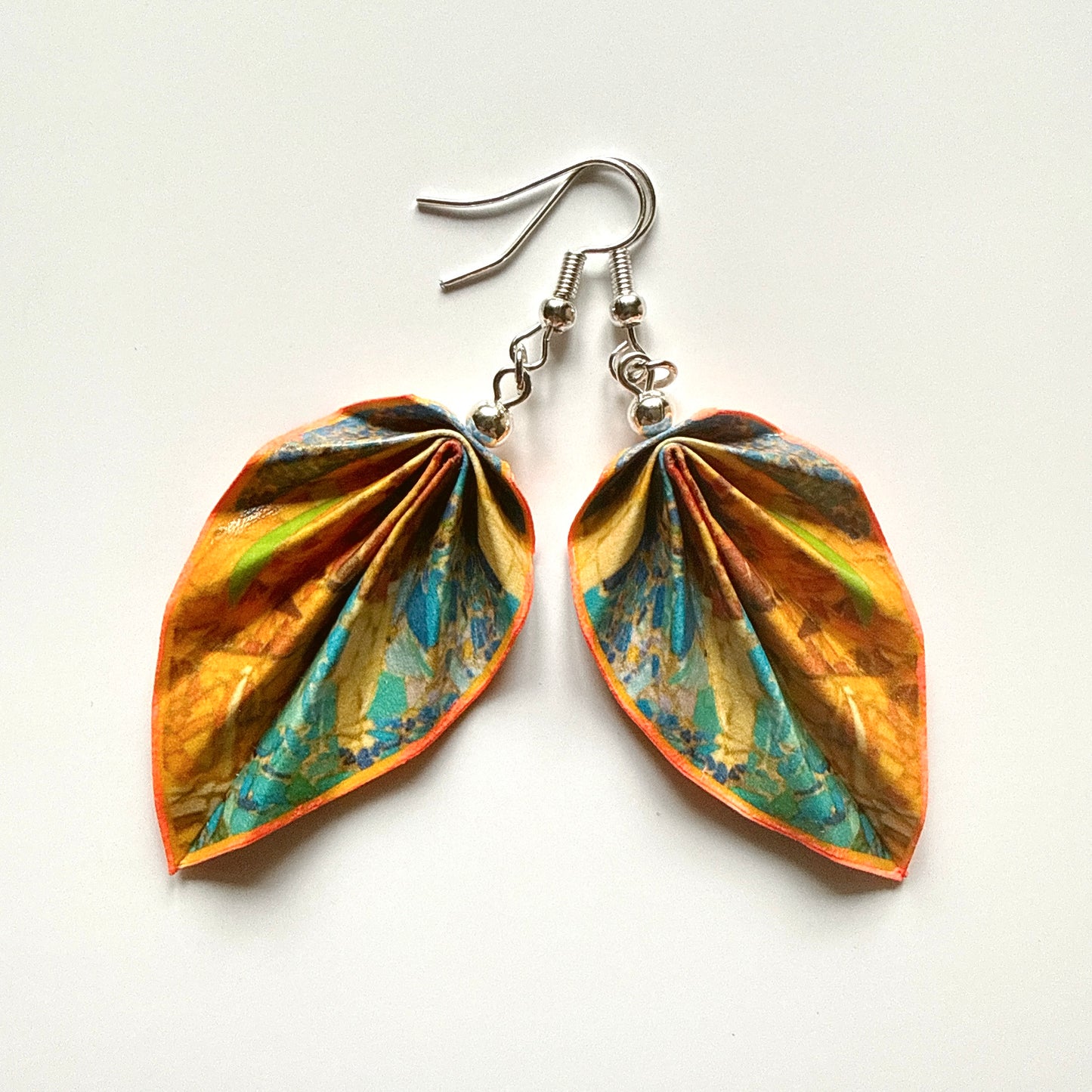 Leaf-shaped earrings with colorful design on a white background