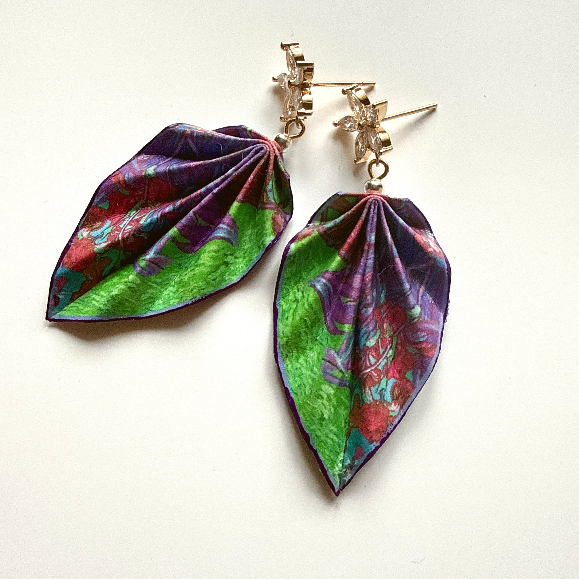 Colorful leaf-shaped earrings on a white background