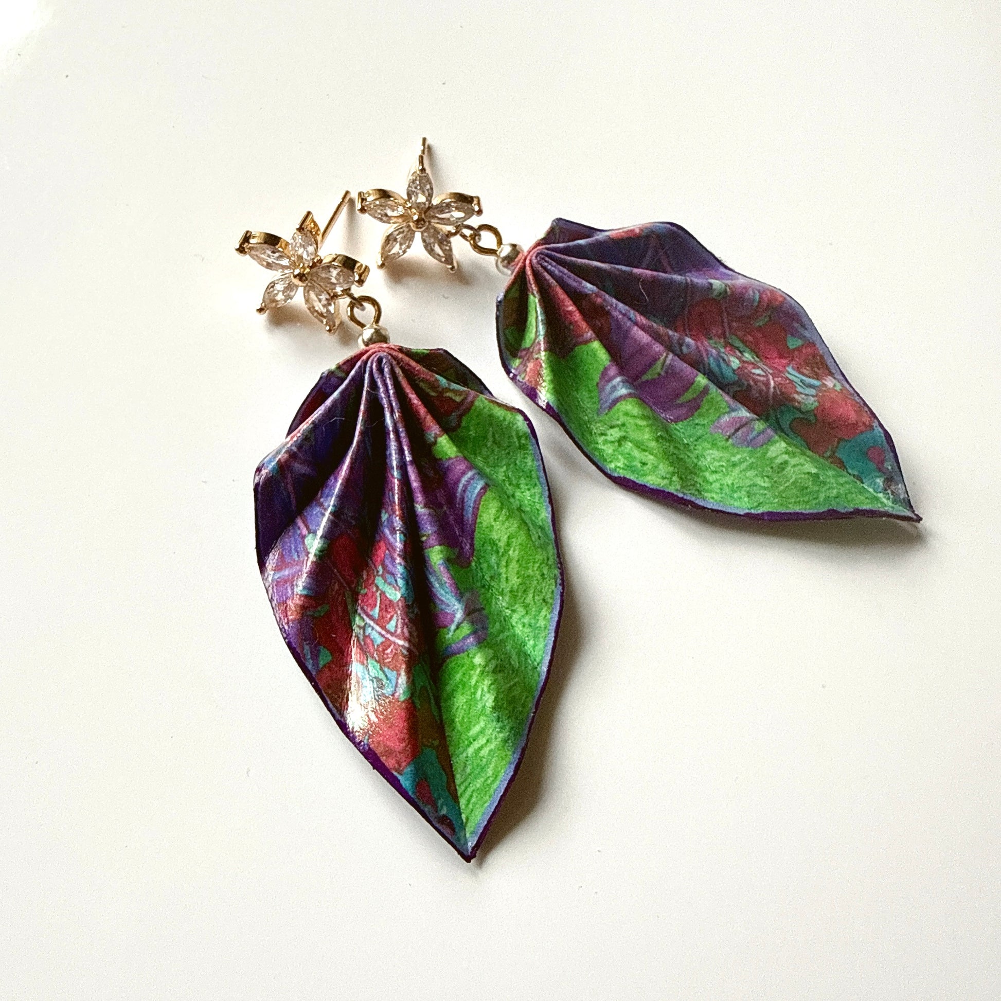 Leaf-shaped earrings with colorful patterns on a white background