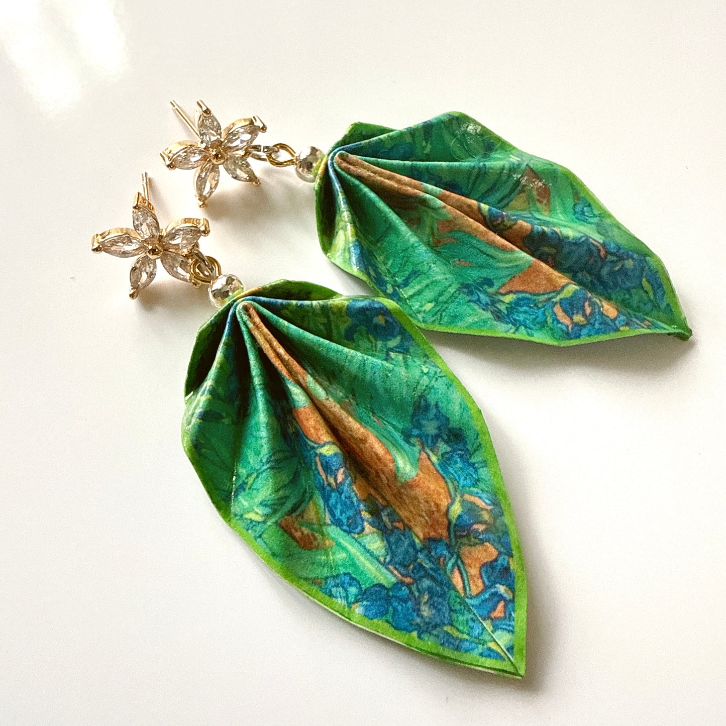 Green floral earrings on a white background