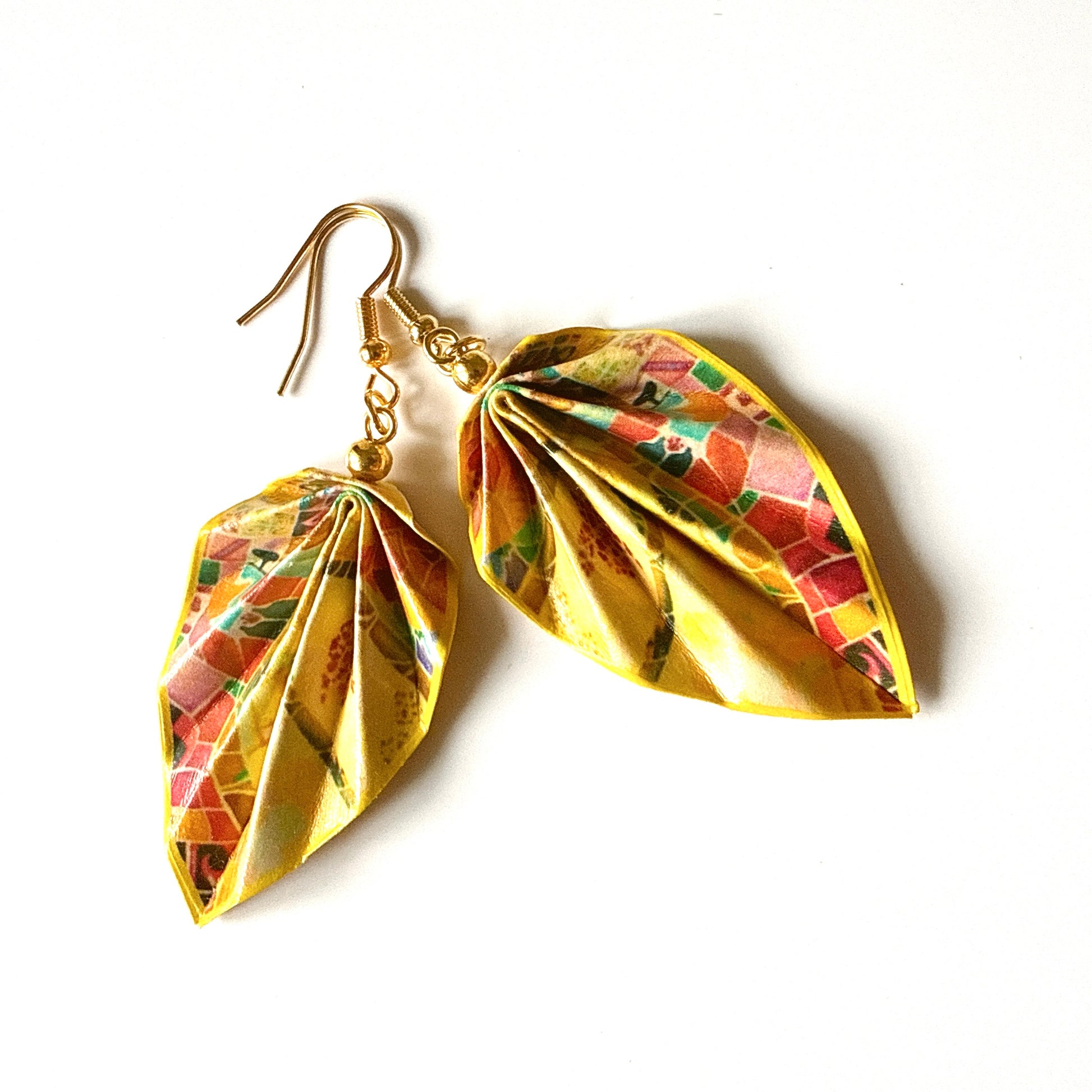 Gold leaf-shaped earrings with colorful patterns on a white background