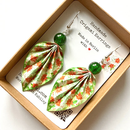 Handmade origami earrings with green and red floral design in a box.