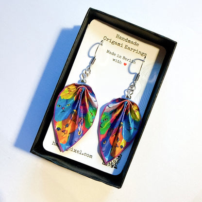 Colorful origami earrings in a black box with a card displaying 'Handmade Origami Earrings' and 'Made in Berlin'.