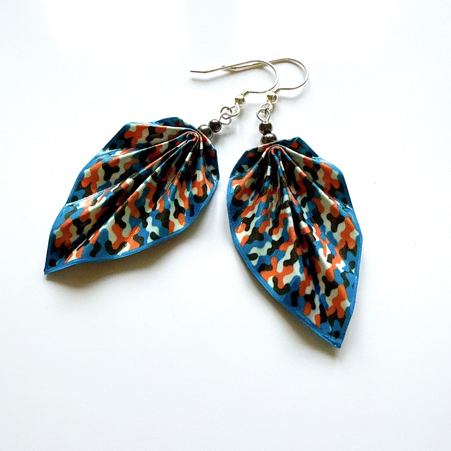 Pair of leaf-shaped earrings with a colorful pattern on a white background