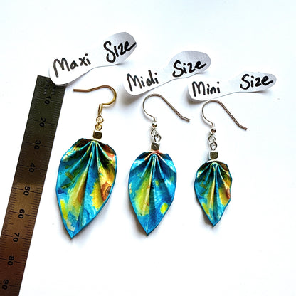 Three pairs of colorful leaf-shaped earrings with size labels and a ruler for scale.