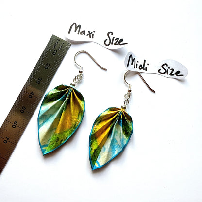 Pair of leaf-shaped earrings with size labels and a ruler for scale on a white background