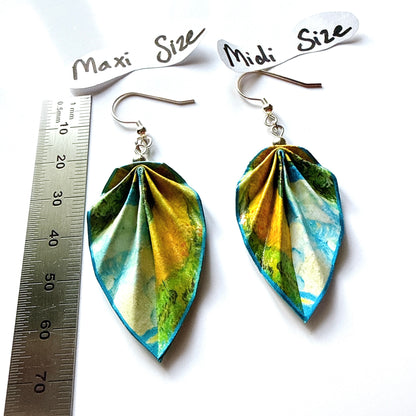 Pair of leaf-shaped earrings with size labels and a ruler for scale on a white background