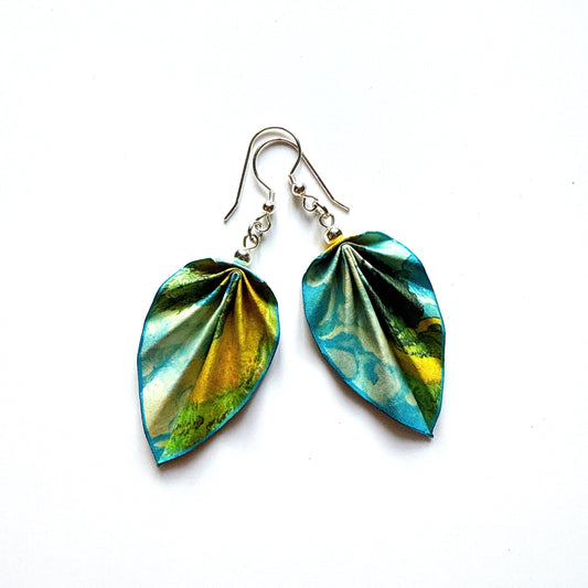 Pair of leaf-shaped earrings with green and blue design on a white background