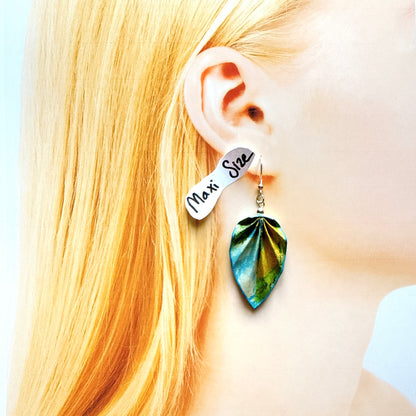 Earring with a leaf-shaped design worn by a person with blonde hair.
