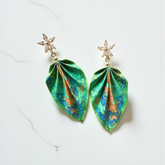 Pair of earrings with green and blue leaf-shaped pendants on a white background