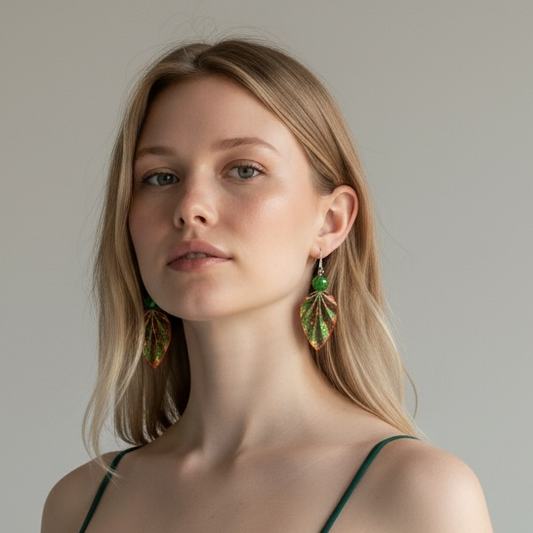Woman wearing green earrings and a green dress against a neutral background